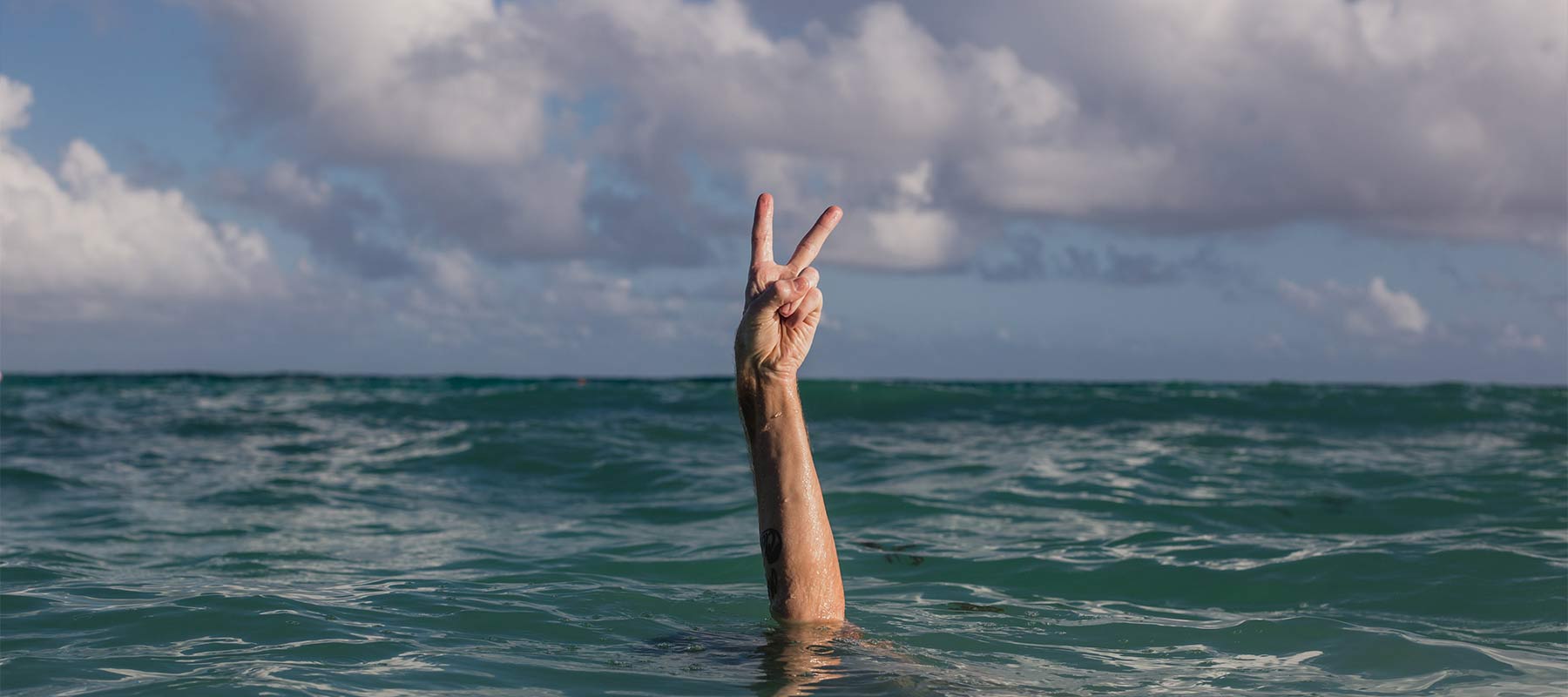 Hand peace sign in water.
