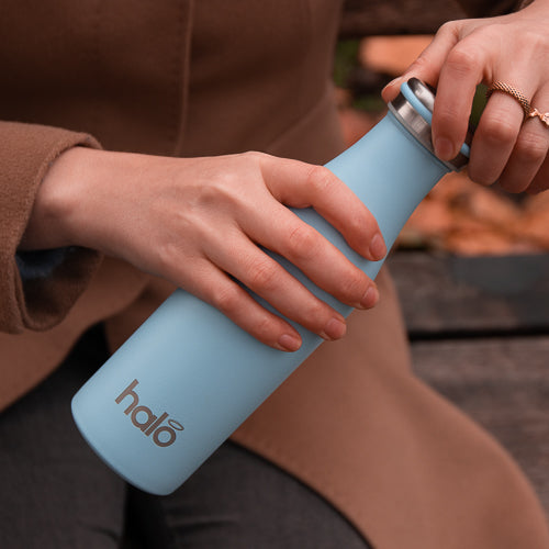 Blue metal water bottle in woman's hand.